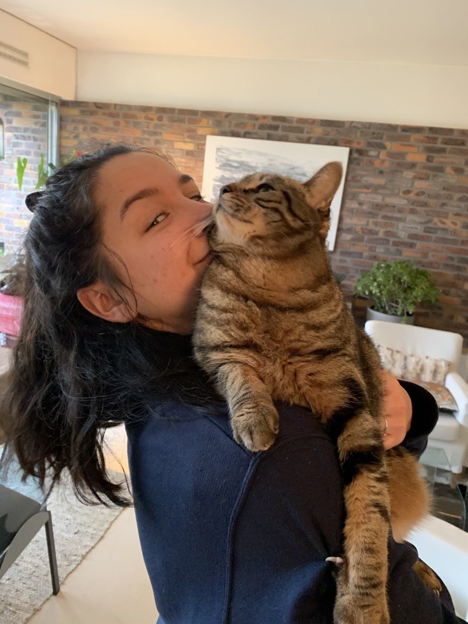 Marion Rahaingomanana avec un chat tigre dans les bras